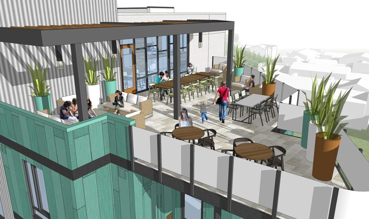 A modern rooftop terrace with people sitting at tables and conversing. The space features wooden accents, large plants, and glass doors leading inside. The view includes a neighborhood in the distance.