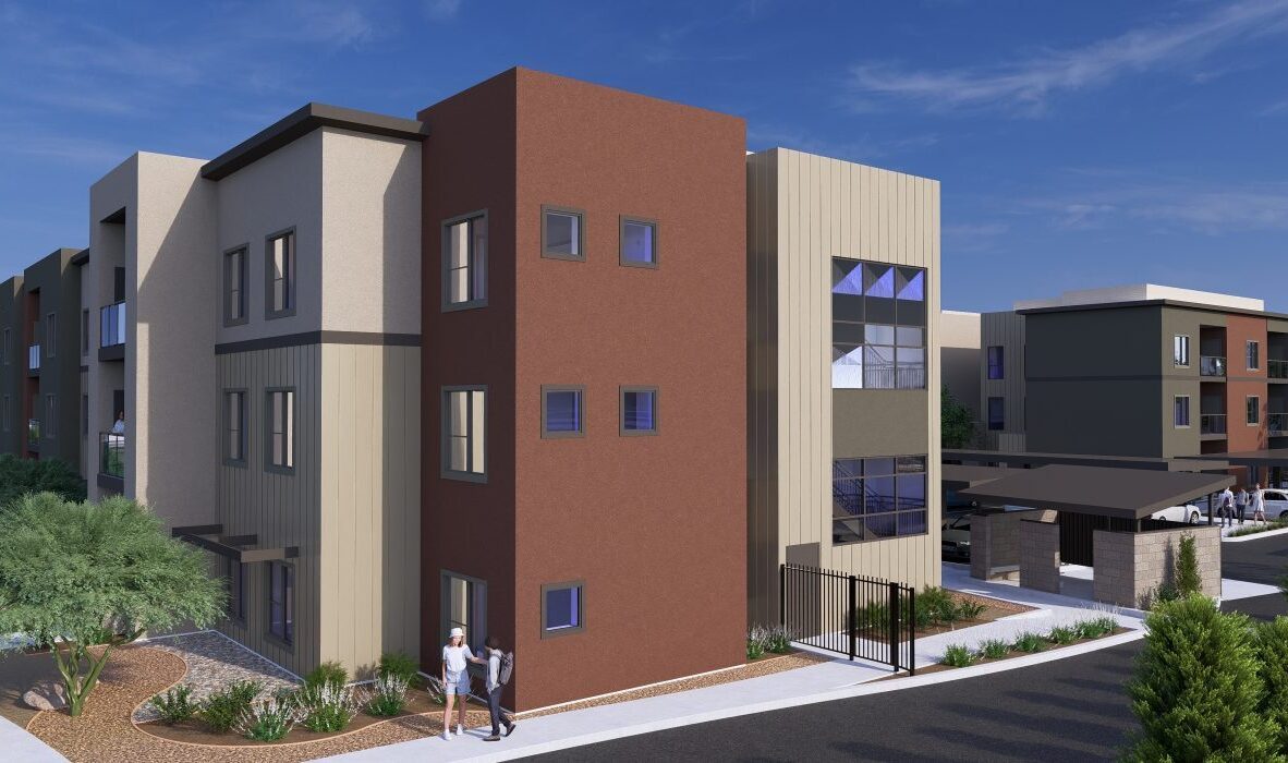 A modern apartment complex with a mix of brown and beige tones, featuring large windows and a landscaped sidewalk. Two people walk near the entrance, and there is a covered parking area to the right. Its a sunny day with a clear blue sky.