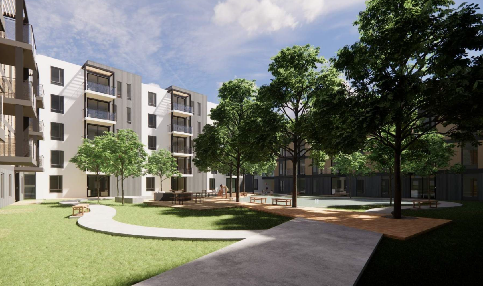 A courtyard with green grass, trees, and a curved path bordered by modern, multistory apartment buildings. Benches and outdoor seating areas are scattered throughout, offering a peaceful urban outdoor space under a partly cloudy sky.
