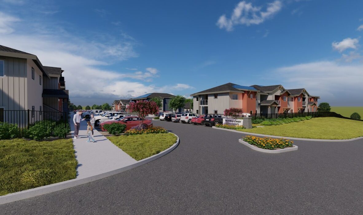 A residential complex with multiple two-story buildings, a parking lot filled with cars, and a group of people walking on a sidewalk. The sky is blue with scattered clouds, and well-maintained lawns and flowerbeds surround the area.