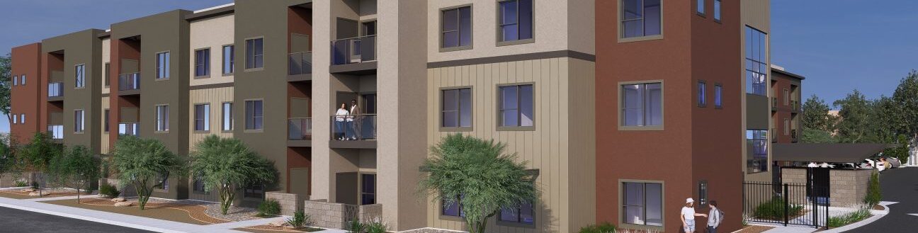 A modern, three-story apartment building with a mix of green, beige, and brown exteriors. The structure features balconies and is surrounded by trees and landscaped pathways under a clear blue sky. Two people are walking on the sidewalk.