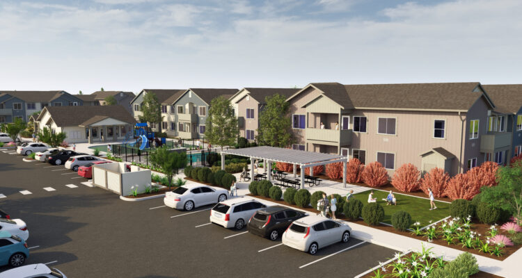 A residential complex with two-story buildings, featuring a parking area filled with cars, a playground with blue equipment, well-maintained landscaping with shrubs and trees, and a clear blue sky in the background.